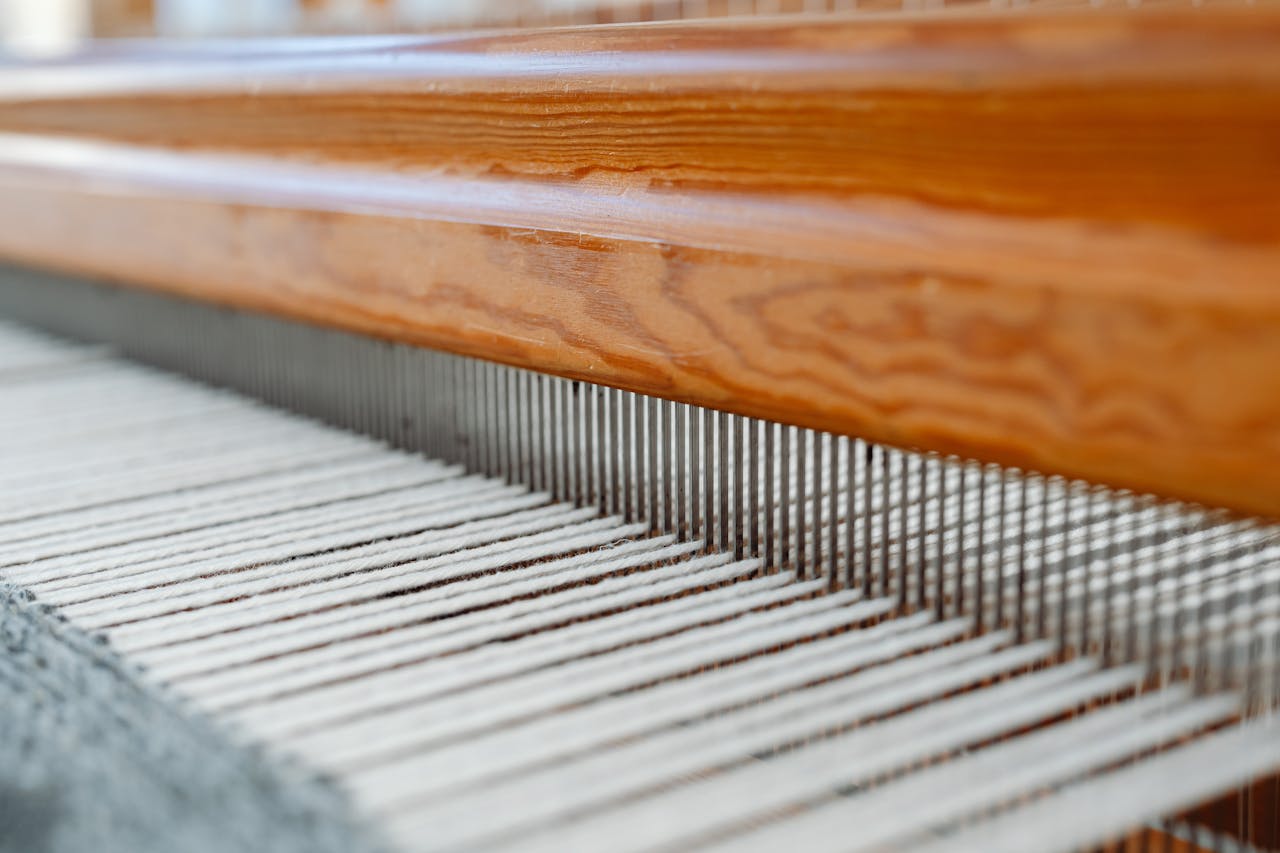 Detailed view of a weaving loom with threads aligned, showcasing textile craftsmanship.